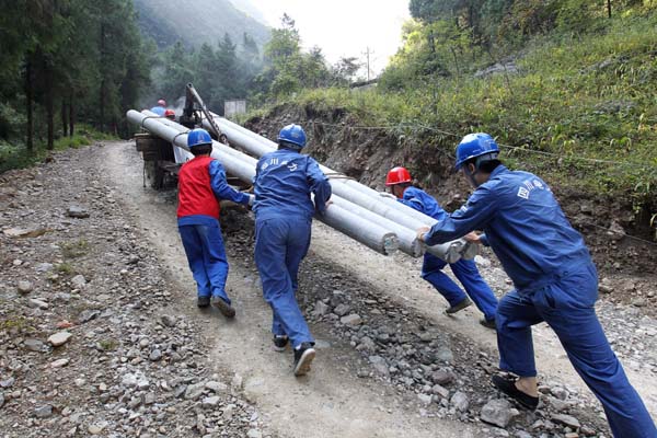 无暇休假 转运电杆上高山